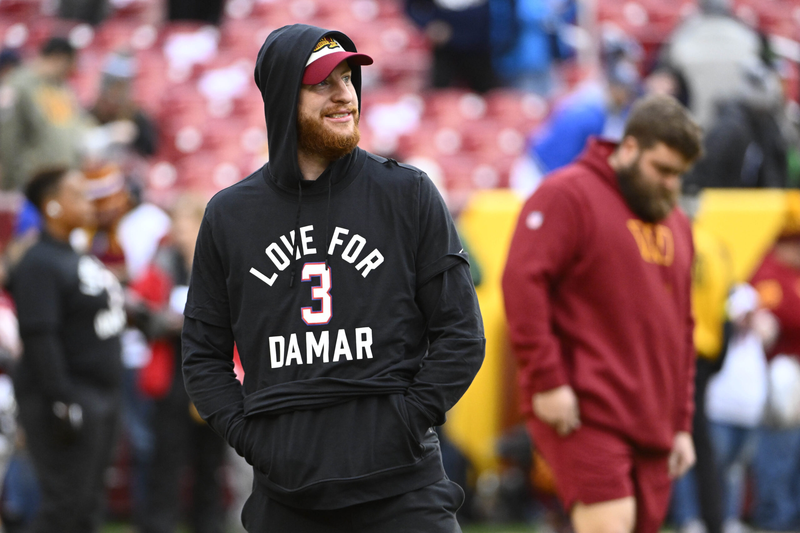Washington Commanders quarterback Carson Wentz on the field wearing a shirt in support of Demar Hamlin before the game against the Dallas Cowboys at FedExField.